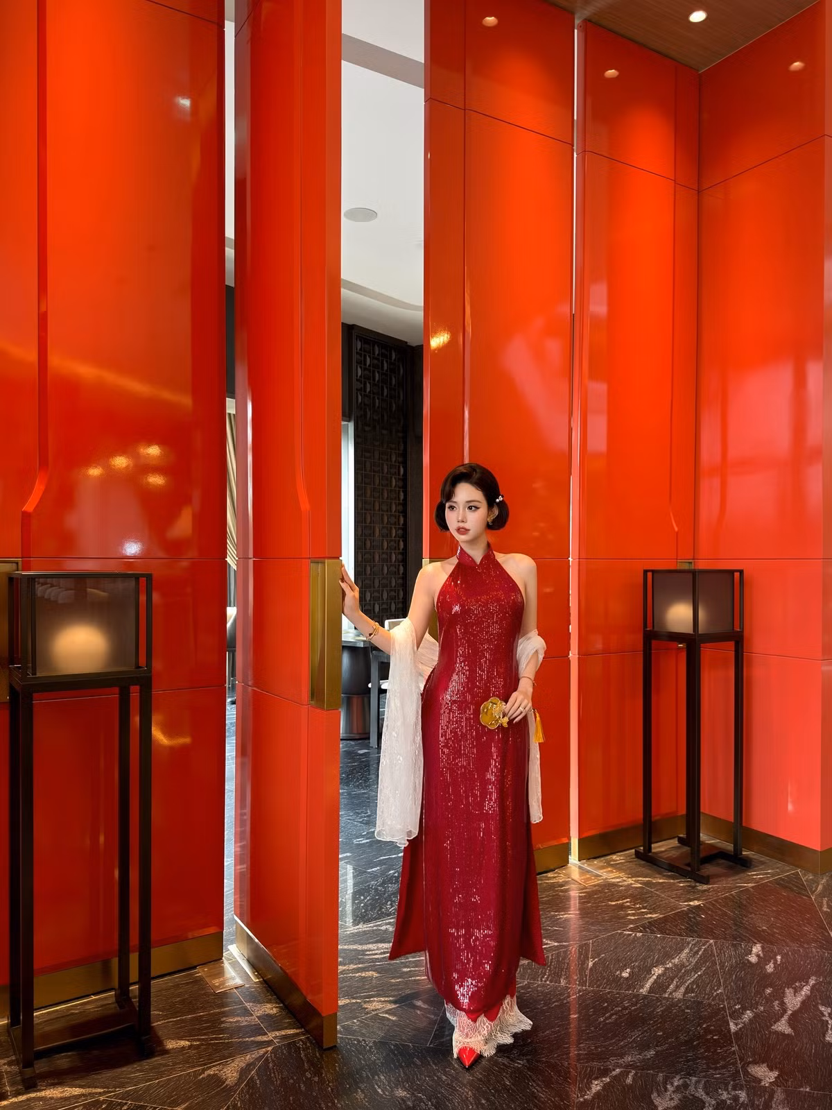 Xuất hiện trong không gian sang trọng với tông đỏ – vàng ấm áp, Chu Mạc Thúy Quỳnh nhanh chóng thu hút mọi ánh nhìn khi lựa chọn áo dài cách tân mang tinh thần giao thoa giữa cổ điển và hiện đại.