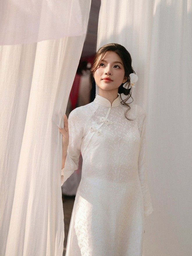 Trong ngày vui, Phương Uyên xuất hiện với vẻ ngoài nền nã trong tà áo dài trắng, chất liệu nhẹ, dáng ôm vừa phải, làm nổi bật vóc dáng thanh thoát.