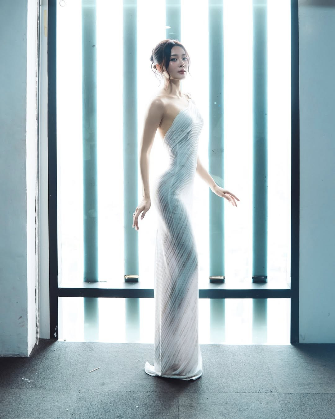 Trong bộ ảnh, Karen Nguyễn diện chiếc váy dài ôm sát, thiết kế bất đối xứng, khoe trọn đường cong mềm mại. Chiếc đầm trắng với chất liệu ôm rũ tôn lên vóc dáng nuột nà và bờ vai trần gợi cảm.