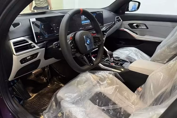 Tiến vào bên trong BMW M3 2024, người dùng sẽ bắt gặp vô lăng 3 chấu với thiết kế vát đáy thể thao mới. Vô lăng M này được bọc da với chấu cải tiến và vạch chỉ hướng 12 giờ màu đỏ. Trên vô lăng còn có 2 nút bấm M để chọn chế độ lái và chỉnh màn hình cong phía sau.