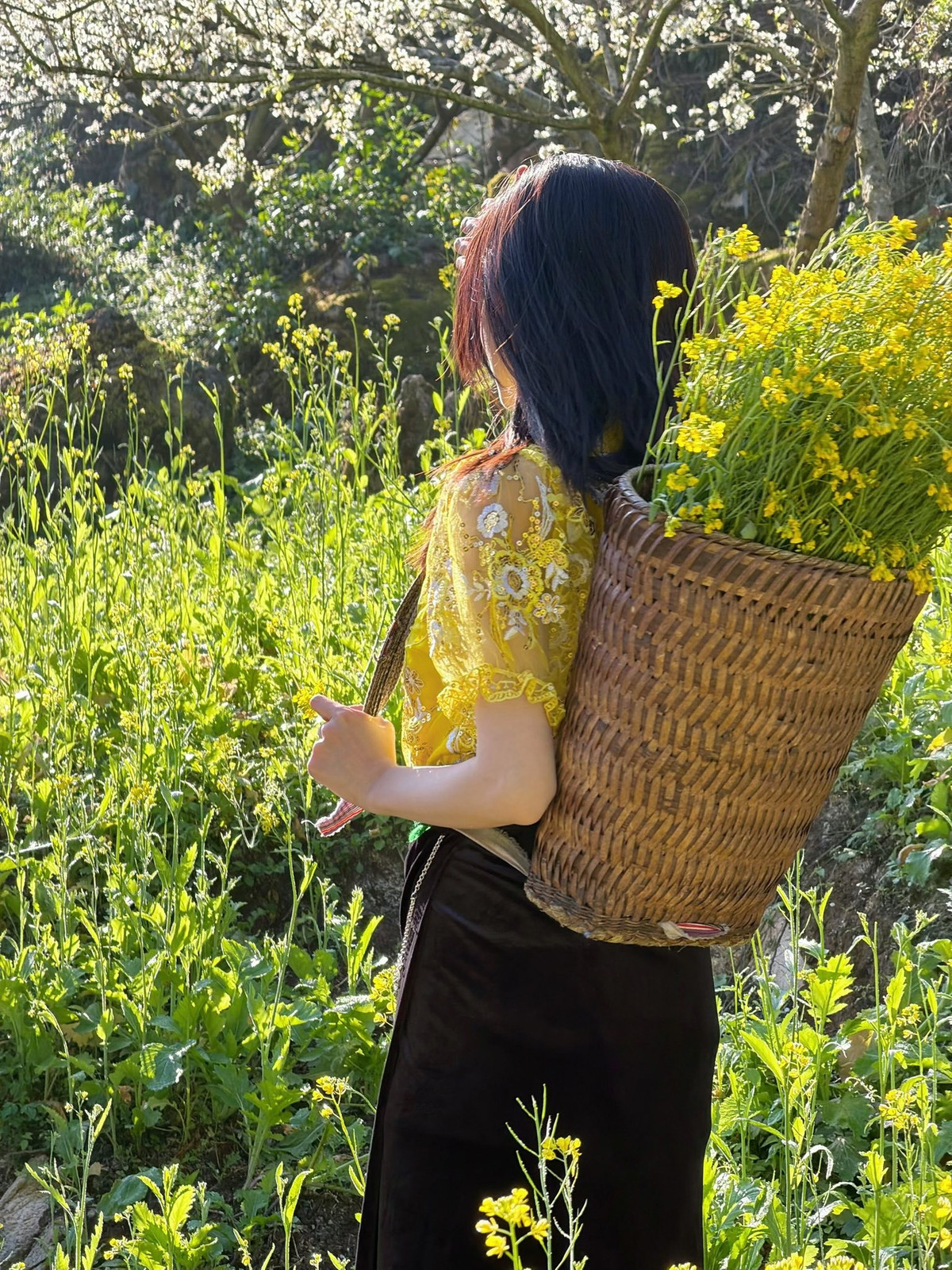 Chiếc thắt lưng xanh bản lớn tạo điểm nhấn ở vòng eo, kết hợp cùng váy đen dài thêu họa tiết truyền thống, mang đến vẻ đẹp vừa nền nã vừa cuốn hút.