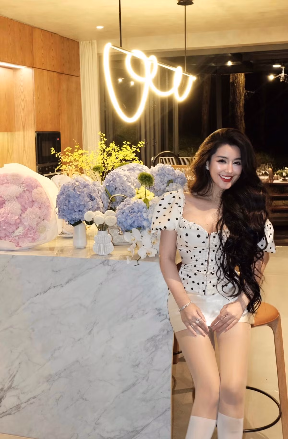 Chiếc corset chấm bi với phần cổ vuông gợi cảm giúp tôn vòng một gợi cảm – đặc trưng làm nên thương hiệu của Ngọc Trân. Kết hợp cùng chân váy trắng và tất mỏng tôn đôi chân thon, nữ hot girl toát lên thần thái kiêu kỳ nhưng không kém phần nữ tính.