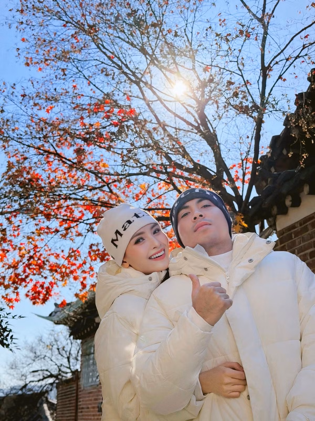 Khung hình mùa đông khi cặp đôi khoác áo phao trắng, đứng dưới những tán cây đỏ mùa cuối năm. Ánh nắng chiếu xuyên qua tán lá, tạo nên bức ảnh đầy chất thơ. Mù Tạt nép vào bạn trai, cả hai rạng rỡ giữa khung cảnh yên bình.