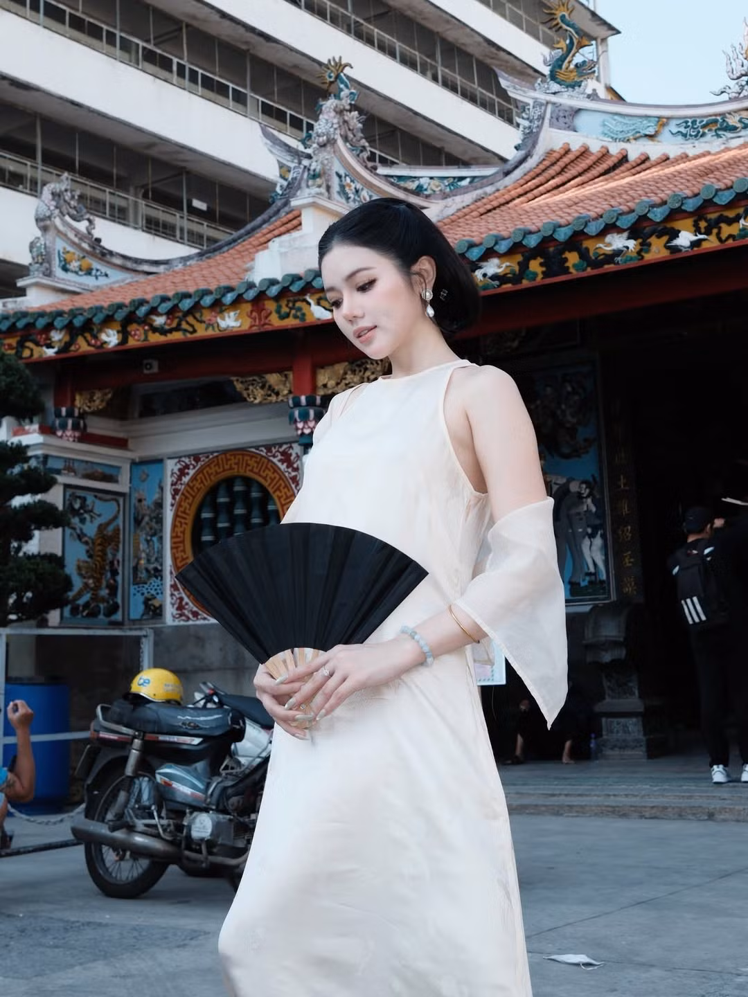 Điểm nhấn của bộ trang phục nằm ở phần tay áo mỏng nhẹ bay bổng, kết hợp cùng phụ kiện vòng tay ngọc và khuyên tai dáng dài, mang hơi thở truyền thống pha lẫn nét hiện đại.