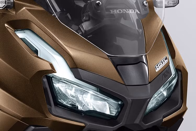 Về ngoại hình, ADV160 2026 vẫn giữ lại dáng vóc đặc trưng của dòng tay ga đa dụng, nhưng có sự tinh chỉnh nhẹ ở phần yếm bên, giúp xe trông cứng cáp và mạnh mẽ hơn. Đèn pha và đèn hậu LED vẫn giữ thiết kế sắc sảo, đồng thời phần chắn bùn phía sau được làm theo phong cách thể thao, tạo nên sự khác biệt so với các mẫu tay ga truyền thống.