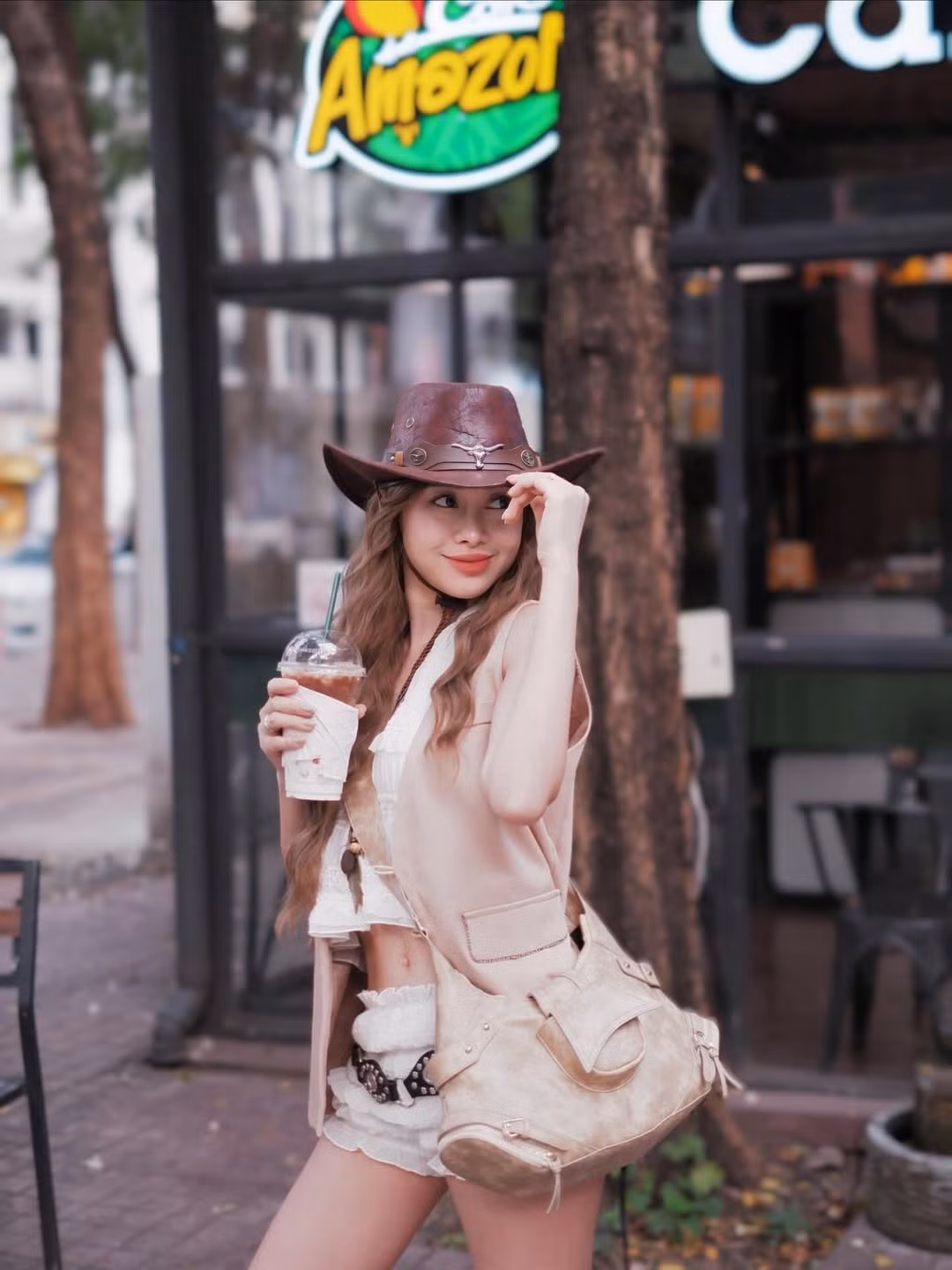 Đôi boots cao màu nâu phối cùng tất ren trắng khiến set đồ vừa mang tinh thần cao bồi phương Tây, vừa có sự nữ tính đặc trưng của Thoa. Ở mỗi khung hình, cô nàng đều toát lên vẻ tự tin, phóng khoáng – đúng tinh thần của một “cowgirl hiện đại”.