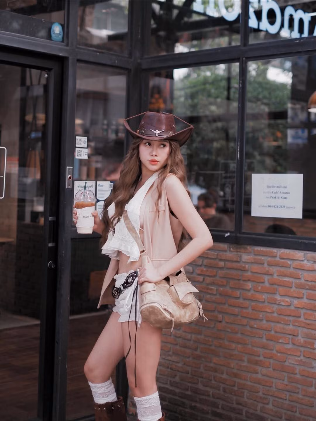 Trong những bức ảnh tại một quán cà phê mang phong cách mộc, Việt Phương Thoa diện bộ outfit tông màu kem – nâu đặc trưng của cowboy style, nhưng được biến tấu để trở nên mềm mại và hiện đại hơn.