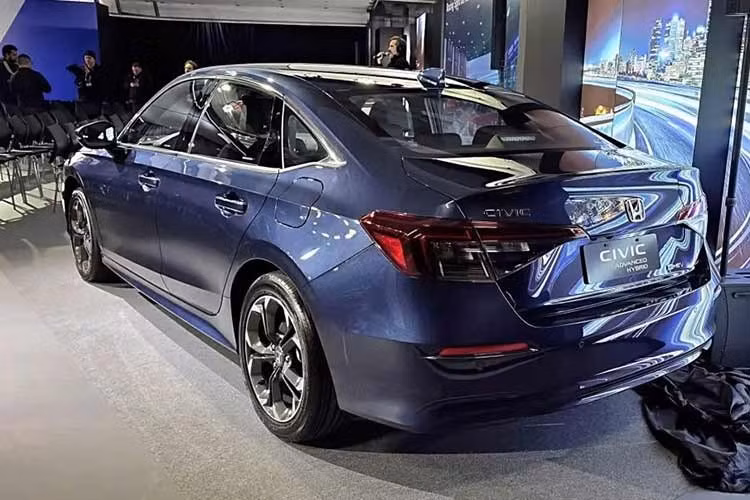 Về ngoại hình, Honda Civic e:HEV 2026 cũng nhận được những nâng cấp ngoại thất tương tự như bản Bắc Mỹ. Bao gồm cản trước được tinh chỉnh, lưới tản nhiệt mới, đèn hậu sơn màu khói. Phiên bản 1.5 Turbo EL+ nâng cấp la-zăng hợp kim 17 inch, trong khi la-zăng 18 inch trên phiên bản e:HEV RS có thiết kế mới.