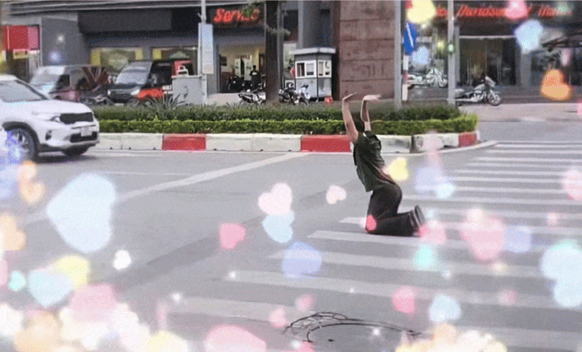 Trong video, Bách Khỉ chạy ra khu vực vạch kẻ đường rồi quỳ xuống, vái lạy các phương tiện phía trước đang dừng chờ đèn đỏ. Sau đó, anh nhanh chóng chạy lại lên vỉa hè.