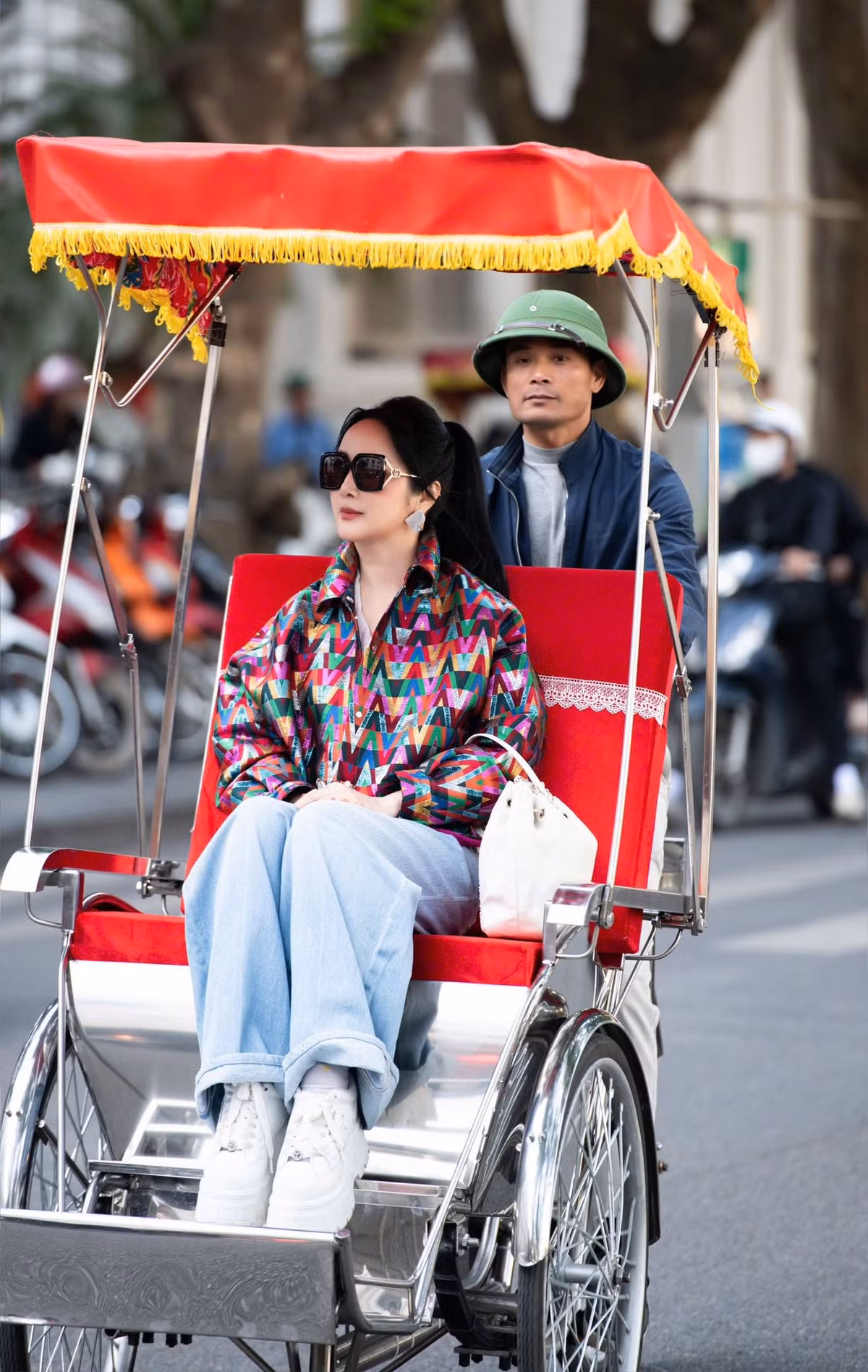 Một trong những hình ảnh đẹp nhất trong bộ ảnh là khi Giáng My ngồi thẳng lưng, đôi tay đặt nhẹ trên đùi, ánh mắt hướng về phố xá đông đúc. Dưới ánh sáng tự nhiên, gương mặt cô trở nên rạng rỡ hơn, nổi bật giữa khung cảnh người qua lại và dãy xích lô nối tiếp nhau phía sau.