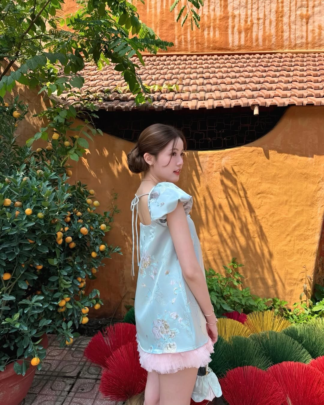 Điểm nhấn phụ kiện cũng được lựa chọn khéo léo. Chiếc túi nhỏ xinh cùng tông xanh với váy, quai đính ngọc trai tạo cảm giác tiểu thư, điệu đà. Những chiếc vòng tay mảnh và dây chuyền nhỏ càng làm tăng vẻ nữ tính mà không hề rườm rà.