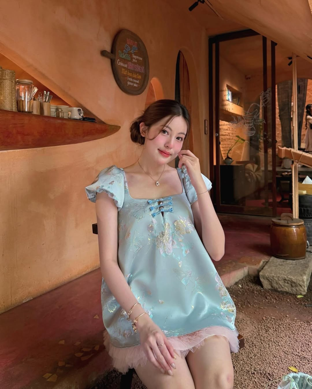 Trong bộ ảnh, “Baby Boo” xuất hiện với chiếc váy xanh pastel điểm họa tiết hoa nhẹ nhàng, kết hợp cùng lớp chân váy voan hồng phấn bên trong tạo hiệu ứng bồng bềnh, nữ tính. Thiết kế tay phồng và chi tiết nơ nhỏ trước ngực càng làm tăng vẻ ngọt ngào, đúng với hình ảnh “kẹo ngọt” mà cô theo đuổi bấy lâu nay.