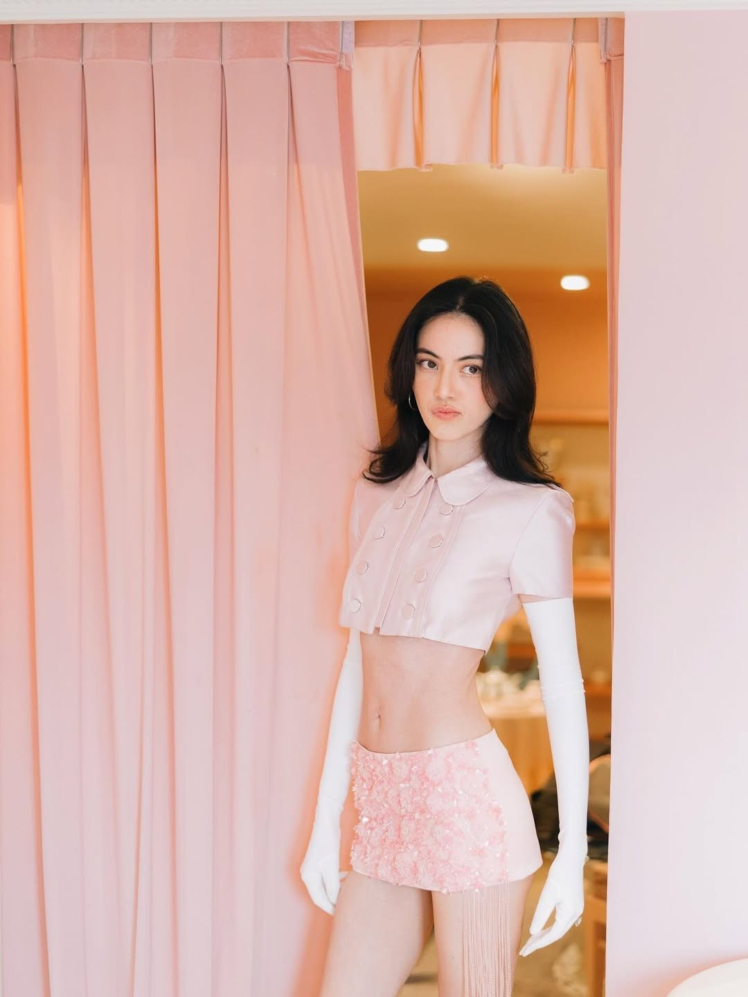 Trong bộ trang phục crop-top và chân váy ngắn ôm sát, Mai Davika khoe trọn vòng eo siêu nhỏ cùng đôi chân thon dài đặc trưng. Tuy nhiên, thân hình mảnh mai đến mức lộ rõ xương quai xanh, cánh tay và đôi chân gầy guộc khiến nhiều fan bày tỏ sự lo ngại.