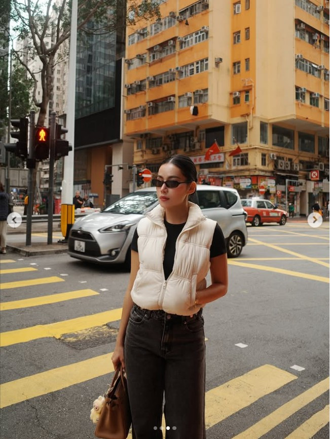 Set đồ tối giản nhưng được phối hợp khéo léo, giúp tôn lên vóc dáng cân đối và thần thái khỏe khoắn. Phụ kiện túi xách hàng hiệu cùng kính râm bản nhỏ tạo điểm nhấn, mang đậm tinh thần thời trang đường phố quốc tế.