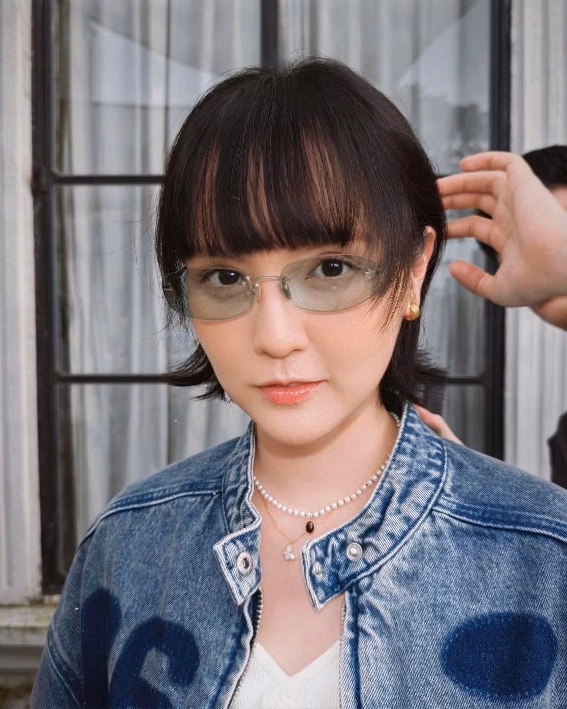 Hải Tú cũng chọn đeo một chiếc kính râm gọng kim loại mỏng với tròng kính màu xanh nhạt, ton-sur-ton với màu bánh kem, tạo nên tổng thể hài hòa và sành điệu. Phụ kiện đi kèm là vòng cổ ngọc trai mix với mặt dây chuyền nhỏ xinh xắn và những chiếc nhẫn vàng lấp lánh ở các ngón tay.