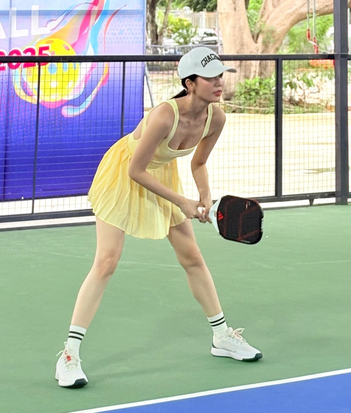 Thay vì những bộ cánh lộng lẫy hay trang phục nội y quen thuộc, Ngọc Trinh xuất hiện với trang phục thể thao năng động, khỏe khoắn với chiếc áo 3 lỗ với những đường cắt táo bạo và chiếc váy bông xòe màu vàng "ton-sur-ton".