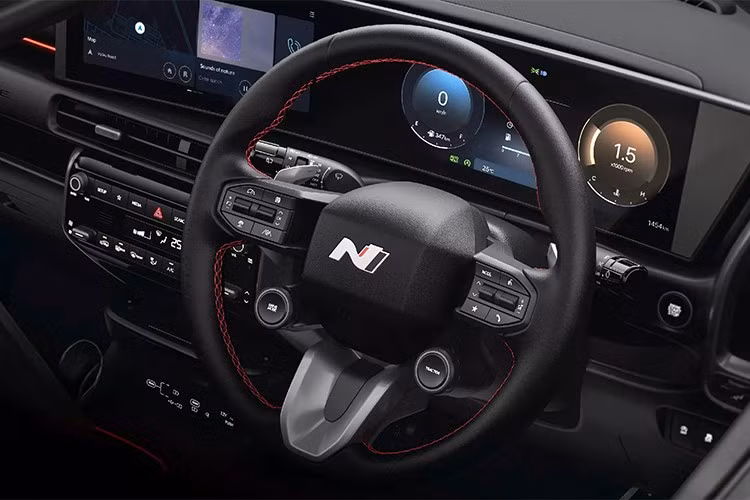 Không gian nội thất được thiết kế theo phong cách thể thao với tông màu đen chủ đạo, điểm xuyết bằng đường chỉ đỏ. Vô lăng có thiết kế tương tự mẫu Ioniq 5 N, tích hợp lẫy chuyển số và núm xoay điều chỉnh chế độ lái.