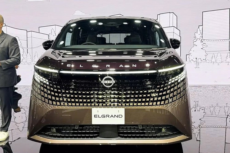 Nhìn chung, bạn sẽ không thể nhầm lẫn phần đầu xe của Nissan Elgrand 2026 với bất kỳ mẫu ôtô minivan nào khác hiện nay. Tại đây, xe được trang bị lưới tản nhiệt lấy cảm hứng từ hoa văn truyền thống Kumiko của Nhật Bản, hòa quyện liền mạch với dải đèn trước.