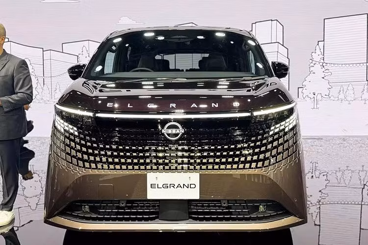 Nhìn chung, bạn sẽ không thể nhầm lẫn phần đầu xe của Nissan Elgrand 2026 với bất kỳ mẫu ôtô minivan nào khác hiện nay. Tại đây, xe được trang bị lưới tản nhiệt lấy cảm hứng từ hoa văn truyền thống Kumiko của Nhật Bản, hòa quyện liền mạch với dải đèn trước.