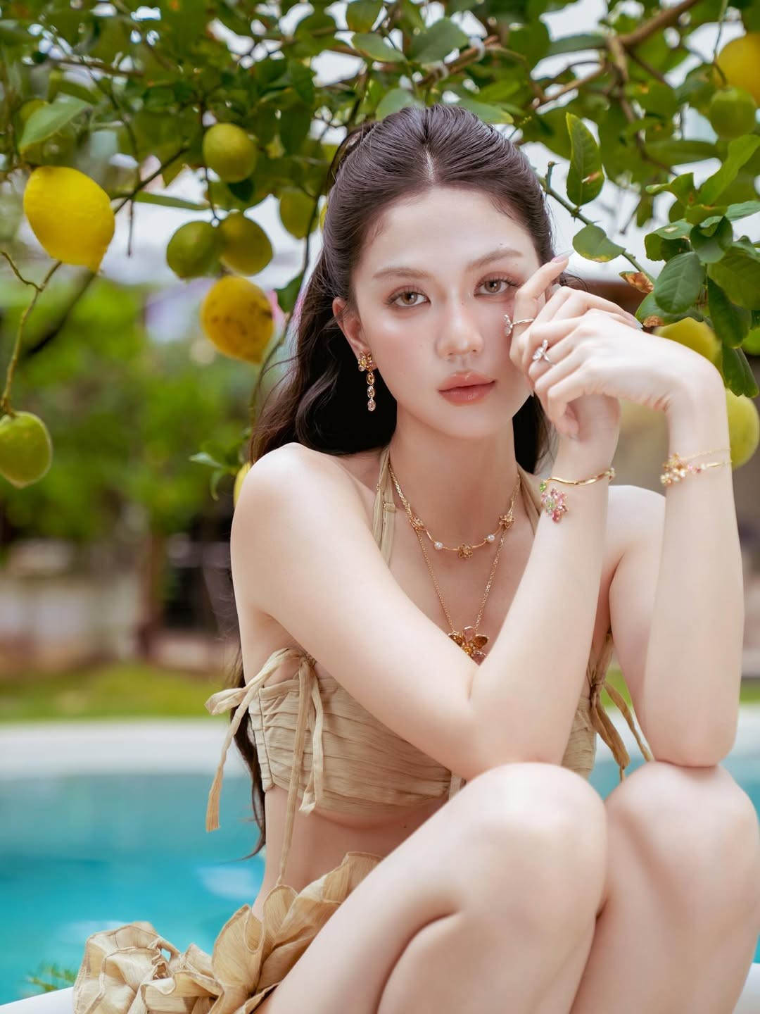 Điểm nhấn của bộ ảnh lần này chính là phong cách trang điểm tự nhiên, mái tóc buông xõa bồng bềnh cùng phụ kiện mặt đá. Tất cả đã tạo nên một tổng thể hài hòa, mang đậm hơi thở của biển cả và sự tự do.