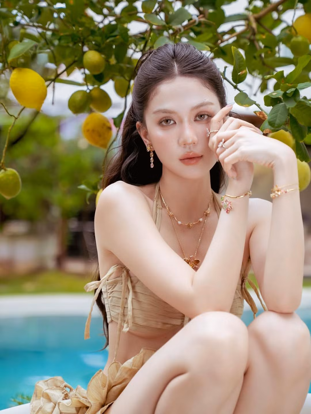 Điểm nhấn của bộ ảnh lần này chính là phong cách trang điểm tự nhiên, mái tóc buông xõa bồng bềnh cùng phụ kiện mặt đá. Tất cả đã tạo nên một tổng thể hài hòa, mang đậm hơi thở của biển cả và sự tự do.