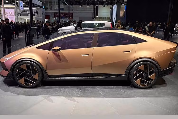 Thân xe Hyundai Ioniq V chạy điện nhìn ngang nổi bật với cửa không viền, tay nắm cửa ẩn một nửa và bộ mâm hình chữ V. Phía sau xe trang bị cụm đèn hậu mỏng, tạo sự tương đồng với đèn trước.