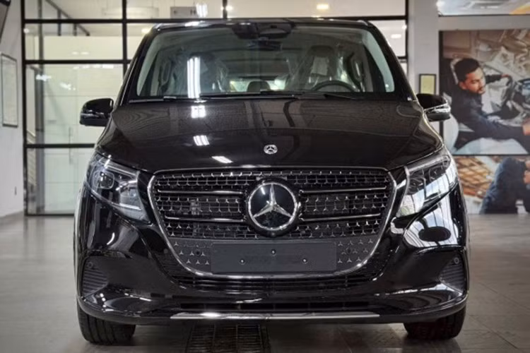 V-Class 2025 sở hữu ngoại thất vẫn mang dáng vẻ bề thế vốn có nhưng đã được bổ sung nhiều chi tiết hiện đại. Cả hai phiên bản đều được trang bị đèn Multibeam LED thông minh, hỗ trợ chiếu xa thích ứng, cùng đèn hậu LED. Lưới tản nhiệt dạng “sao rơi” mới mang dấu ấn đặc trưng của Mercedes-Benz.