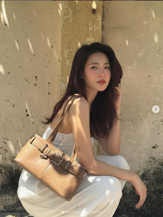 Minh Trang chọn kiểu tóc búi cao gọn gàng, nhưng vẫn để lơi vài sợi tóc mai bay nhẹ trong gió, tạo cảm giác tự nhiên, bay bổng.