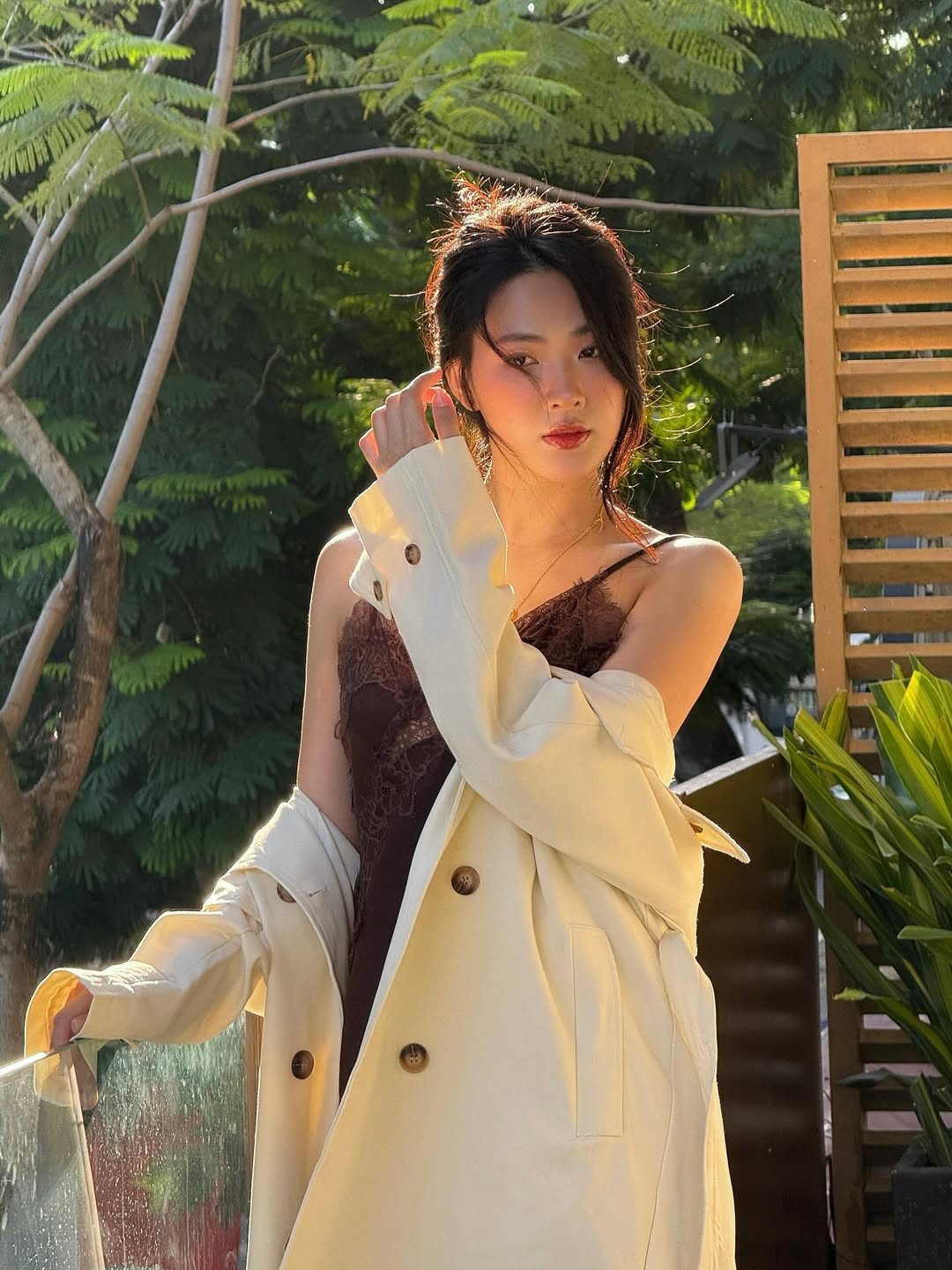 Nữ diễn viên khéo léo khoác hờ một chiếc áo măng-tô màu kem nhạt bên ngoài, tạo nên sự tương phản màu sắc thanh lịch.