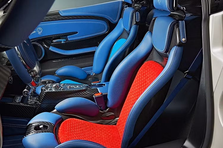Sự cá nhân hóa sâu rộng tiếp tục được thể hiện bên trong cabin với nội thất bọc da màu xanh dương và đường chỉ khâu màu trắng. Ghế ngồi được trang trí bằng các chi tiết màu đỏ và xanh ngọc lam, cùng các sọc tương ứng trên cần số. Tất nhiên, có rất nhiều chi tiết sợi carbon lộ ra và các điểm nhấn kim loại phía sau khắp cabin.