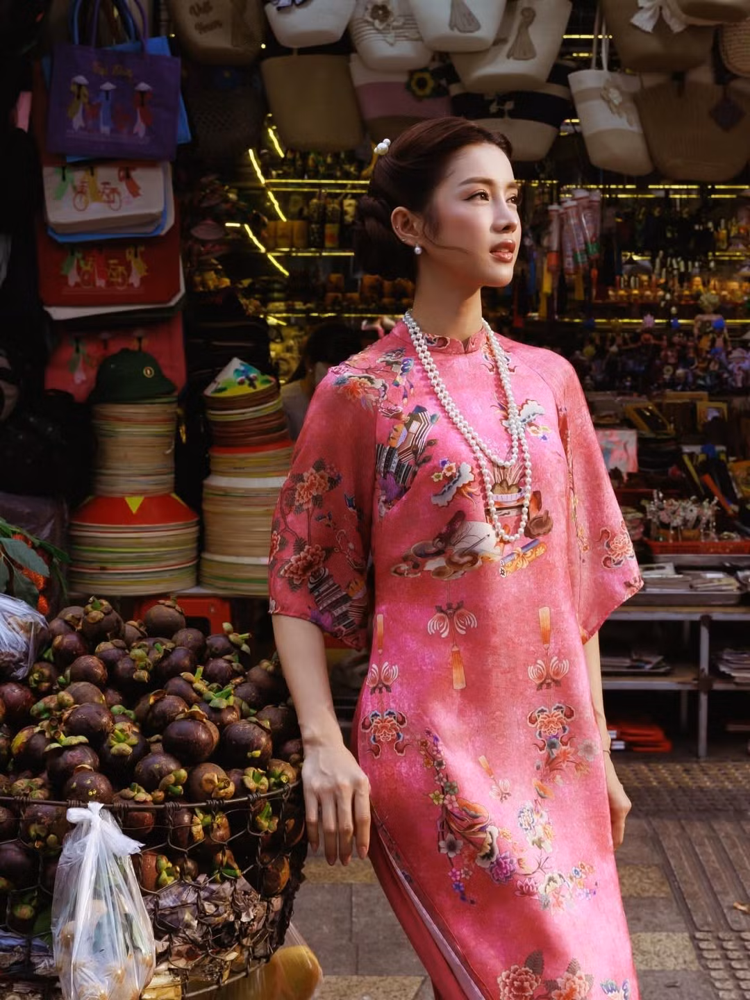 Giữa dòng xe tấp nập và những quầy hàng rực màu trái cây nhiệt đới, hình ảnh Trình Mỹ Duyên diện áo dài nổi bật như một thước phim điện ảnh giữa đời thường. Gương mặt sáng, nụ cười tươi cùng thần thái nhẹ nhàng giúp người đẹp nhanh chóng trở thành tâm điểm mỗi nơi cô dừng chân.