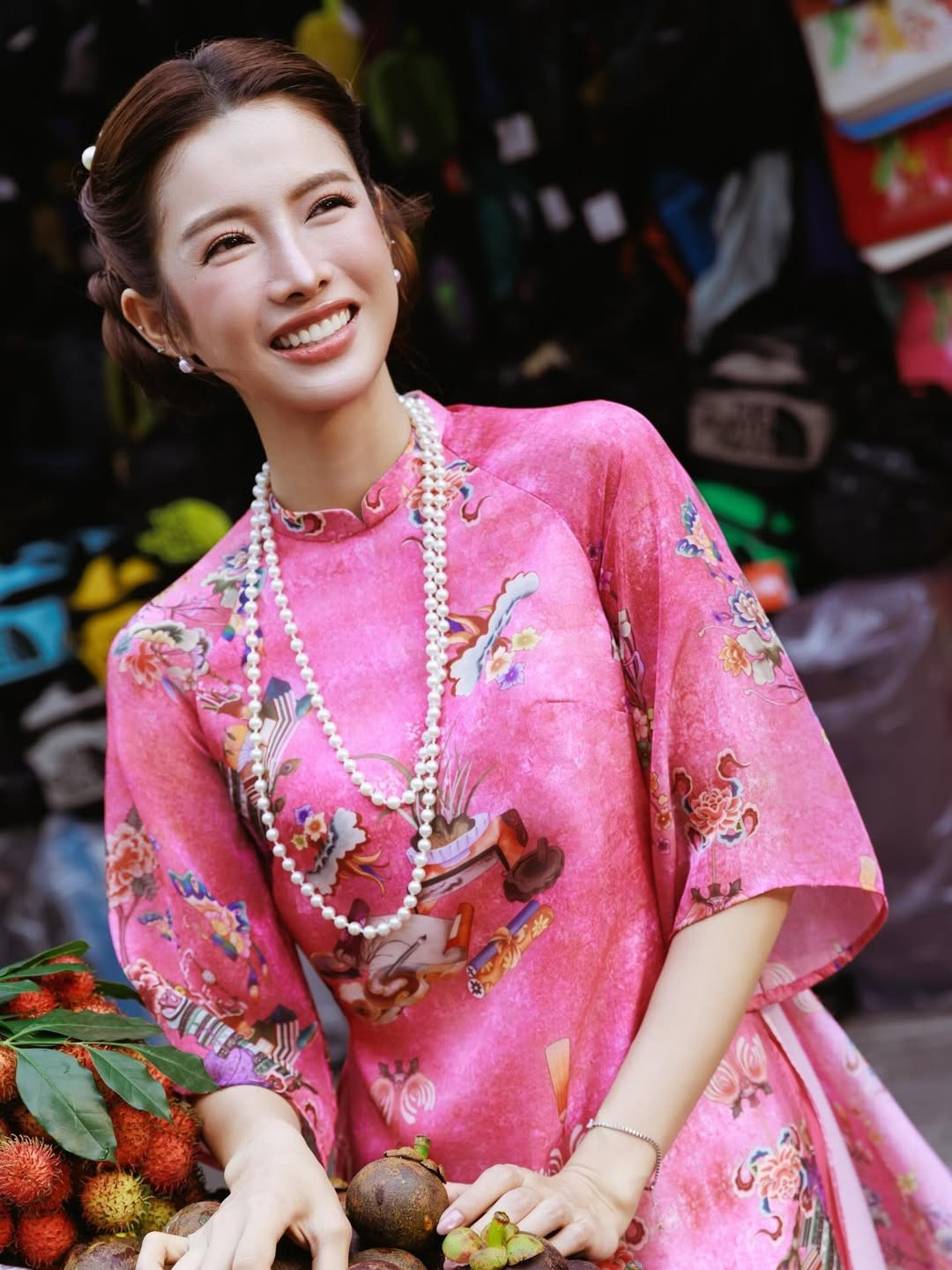 Bộ áo dài màu hồng sen được Mỹ Duyên lựa chọn khéo léo, vừa tôn làn da, vừa mang đến cảm giác trẻ trung, rạng rỡ. Họa tiết cổ điển pha nét hiện đại, kết hợp cùng chuỗi ngọc trai dài và kiểu tóc vấn gọn gàng, giúp tổng thể vừa mang hơi thở truyền thống, vừa có chút hơi hướng thời trang đương đại. Không quá cầu kỳ phụ kiện, chính sự tiết chế này lại làm nổi bật vẻ đẹp thanh lịch, đúng tinh thần áo dài Việt.