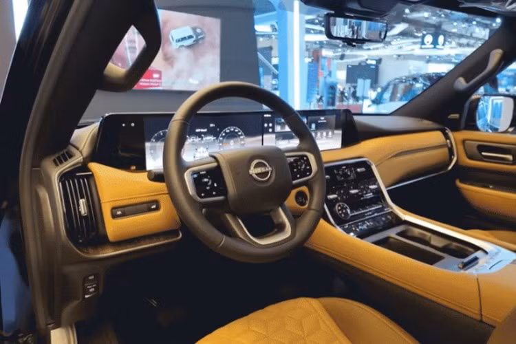 Khoang nội thất Nissan Patrol 2025 mang thiết kế hiện đại và hoàn toàn mới so với thế hệ cũ. Vô lăng bọc da tích hợp các phím chức năng có đèn nền, kết hợp cụm màn hình đôi kích thước 28,6 inch (14,3 inch mỗi bên) tạo cảm giác liền mạch, đậm chất công nghệ.