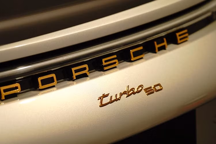 Thiết kế đuôi xe tạo điểm nhấn với dòng chữ "Turbo 50" và "Porsche" được mạ vàng sang trọng. Đèn hậu LED liền mạch được phủ lớp màu xám khói, góp phần tăng vẻ độc đáo cho phiên bản kỷ niệm.