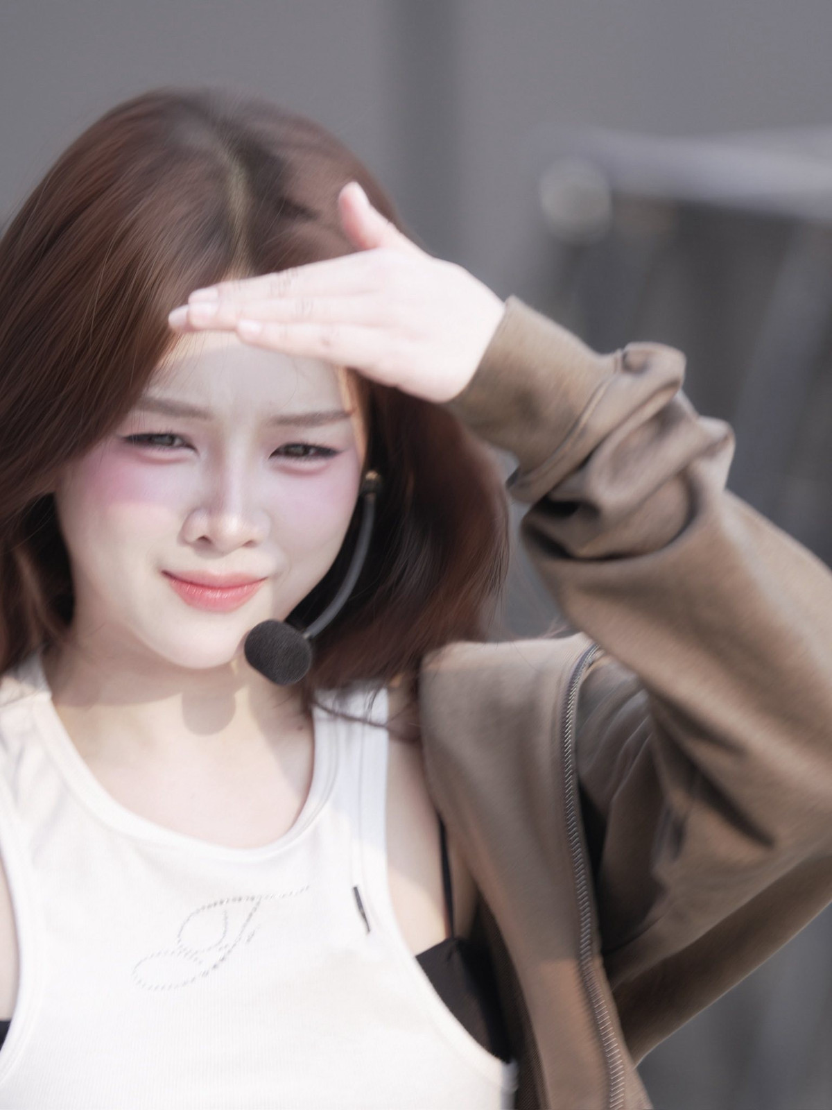 Mái tóc dài nâu nhẹ buông tự nhiên theo từng chuyển động, kết hợp micro đeo tai quen thuộc, tạo nên hình ảnh một DJ tập trung cao độ cho phần trình diễn.