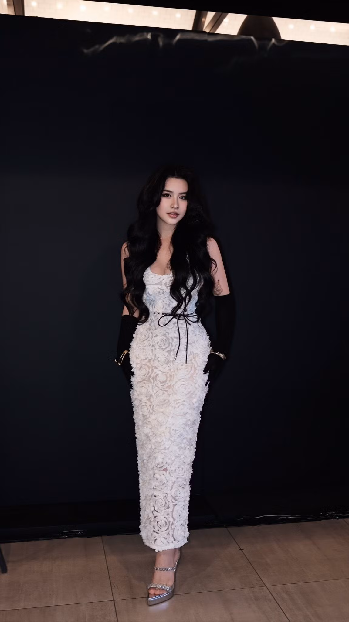 Thiết kế cổ sâu tinh tế khiến vòng một của người đẹp trở nên quyến rũ nhưng không phô trương, trong khi phần thắt eo được điểm bằng dây ruy-băng mảnh càng làm nổi bật vòng eo nhỏ gọn đặc trưng của cô.