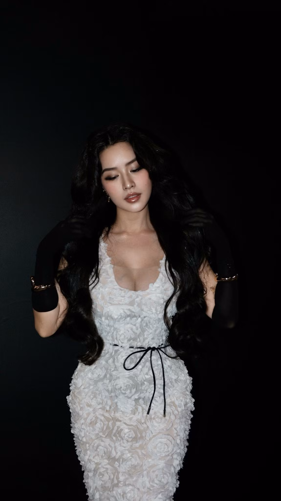 Trong loạt ảnh tại sự kiện, Quyên Qui diện chiếc đầm trắng ôm dáng được tạo hình từ những bông hoa nổi 3D, giúp tôn trọn đường cong cơ thể.