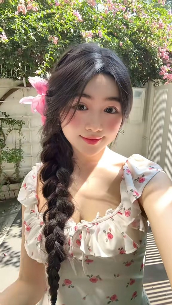 Trong ảnh, Lọ Lem diện chiếc váy hoa trắng nhẹ nhàng, thiết kế tay bồng tôn lên vẻ nữ tính và thanh lịch. Làn da trắng mịn nổi bật dưới ánh nắng mai, kết hợp với đôi má hồng tự nhiên tạo tổng thể trẻ trung, tươi tắn.