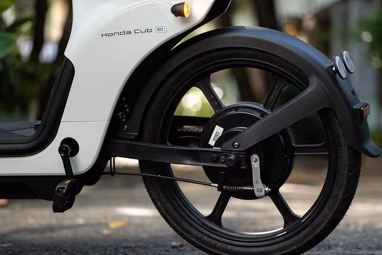 Trong khi đó, đèn xi nhan được đặt ở hai bên, gần tay lái. Đồng hồ công tơ mét dạng kỹ thuật số, hiển thị các thông số cơ bản như dung lượng pin, số ODO và tốc độ. Ngoài ra, Honda Cub E còn được tích hợp tính năng kết nối với điện thoại thông minh, từ đó người dùng có thể theo dõi các thông tin về dung lượng pin, quãng đường hay định vị GPS.