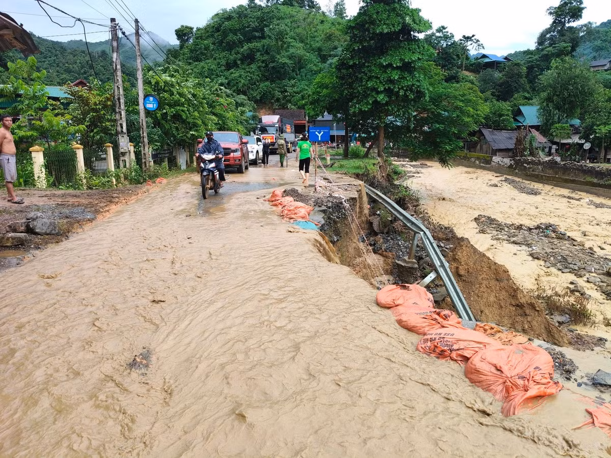Nước từ khe núi vẫn không ngừng chảy tràn qua đường khiến điểm sạt lở thêm nghiêm trọng, gây nguy hiểm cho các phương tiện qua lại.