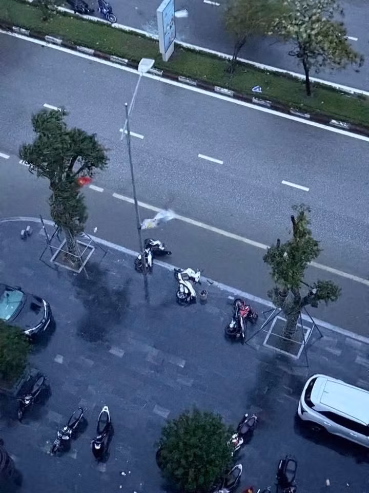 Xe máy dưới chung cư ở trung tâm Thành Vinh bị gió quật đổ xuống đường.