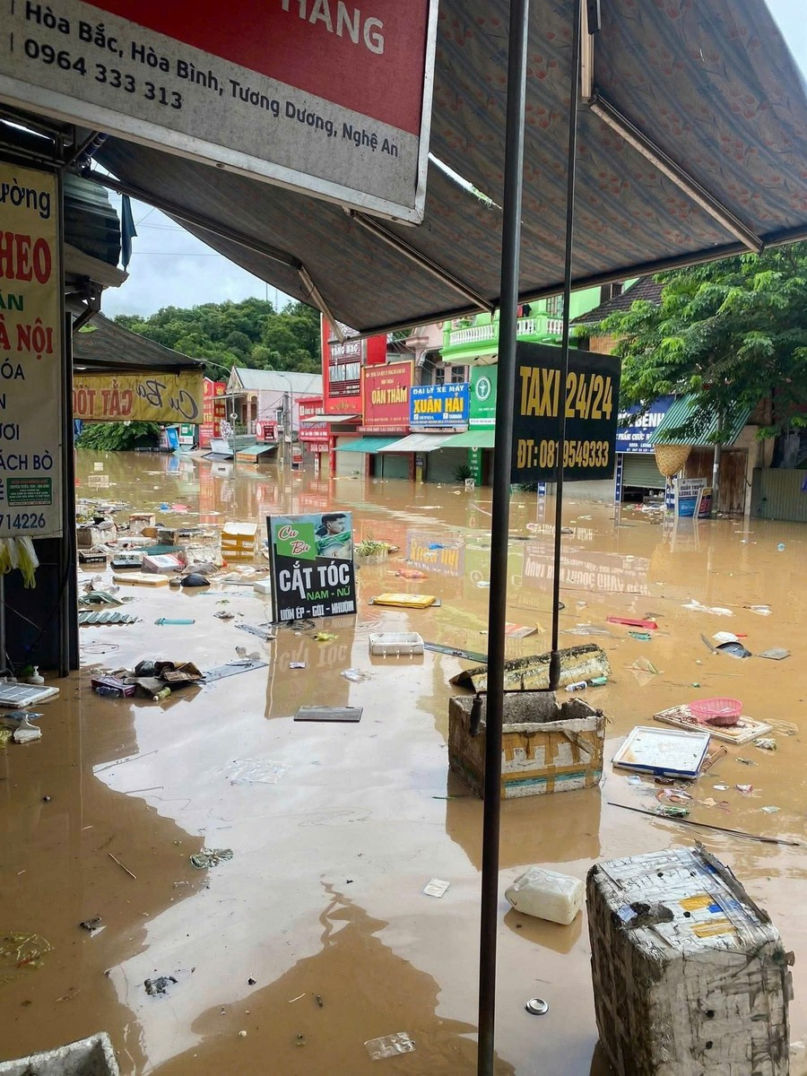 Nhiều tuyến đường ở xã Tương Dương ngập hơn 2 m, xung quanh ứ đọng nhiều đồ dùng, mái tôn, rác thải. Các cửa hàng chìm trong biển nước.