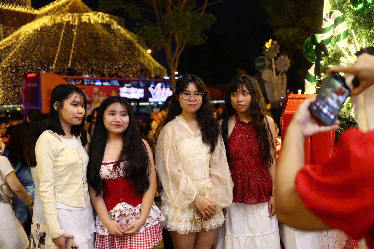 Nhiều nhóm bạn trẻ, các cặp đôi và gia đình có mặt từ sớm, không ngại xếp hàng để có vị trí thuận lợi, ghi lại bức hình kỷ niệm đêm Giáng sinh.