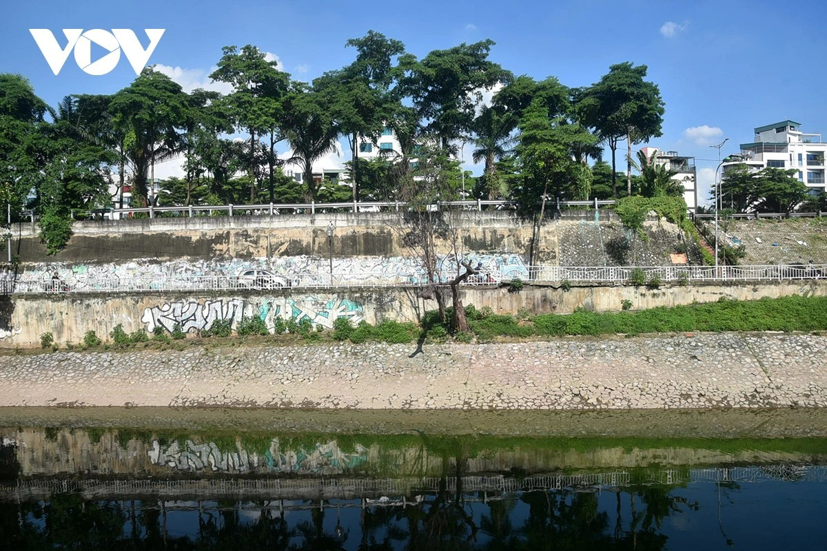 Mặt nước phẳng lặng không còn đen kịt, có thể soi thấy bóng các vật ven bờ.