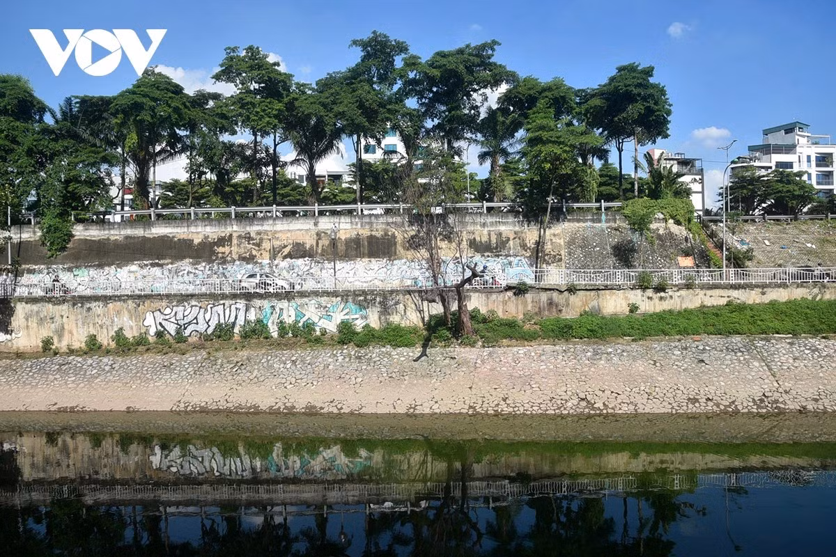 Mặt nước phẳng lặng không còn đen kịt, có thể soi thấy bóng các vật ven bờ.