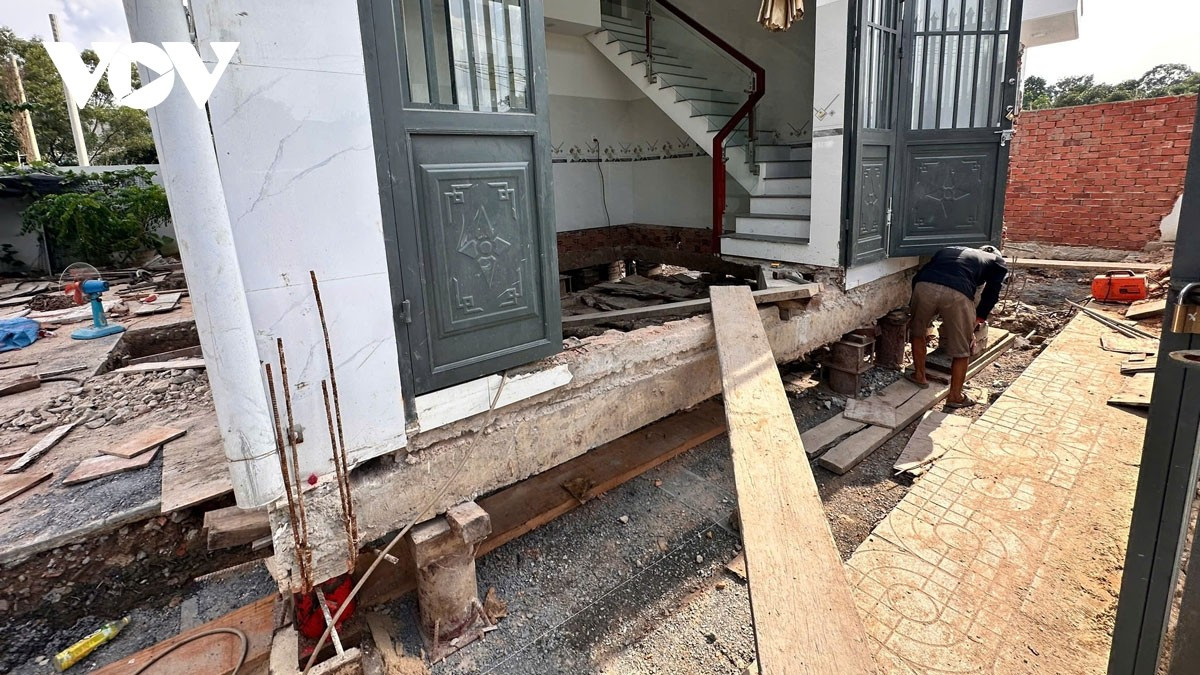 Công nhân đang nâng nhà lên để đặt con lăn