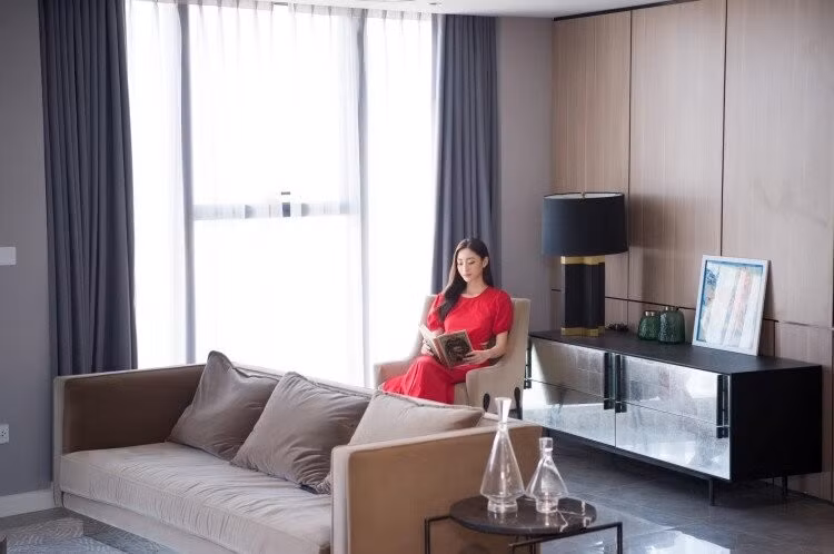 Nội thất trong nhà được thiết kế theo phong cách tối giản với gam màu trung tính như xám, trắng, be và nâu. Phòng khách nổi bật với bộ sofa nâu, tường ốp vân đá đen-xám, kết nối liền mạch với bếp. Ảnh: FBNV
