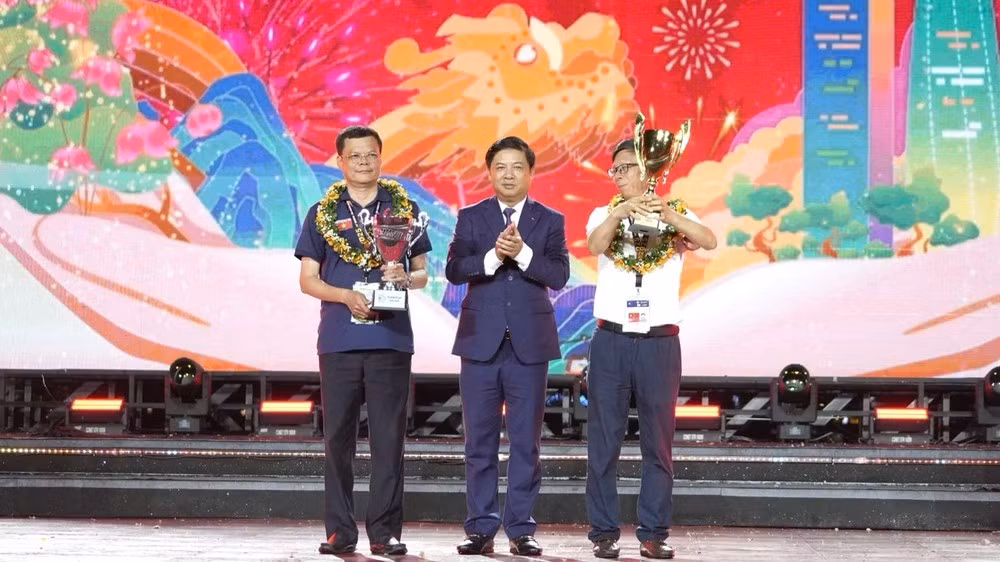 Đại diện đội pháo hoa đến từ Trung Quốc (bên phải) nhận chức vô địch, cùng đại diện đội Á quân - Z121 của Bộ Quốc phòng Việt Nam. Ảnh: TẤN VIỆT