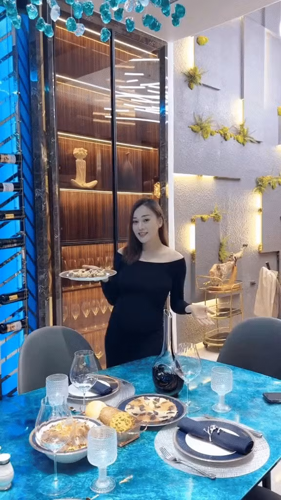 Bàn ăn rộng với mặt đá xanh và đèn trần cùng tone màu mang đến cảm giác tươi mát, dễ chịu. Ảnh chụp màn hình