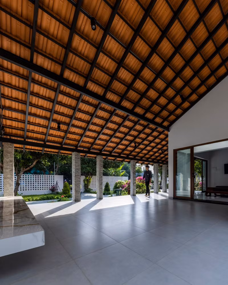 Hành lang này không chỉ đón ánh sáng tự nhiên và cây xanh vào nhà mà còn dẫn hướng dòng không gian từ sân trước ra cánh đồng rộng lớn phía sau. Ảnh: Hiroyuki Oki